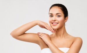Young woman lifting her arm to show her smooth underarm after laser hair removal with Fotona laser.